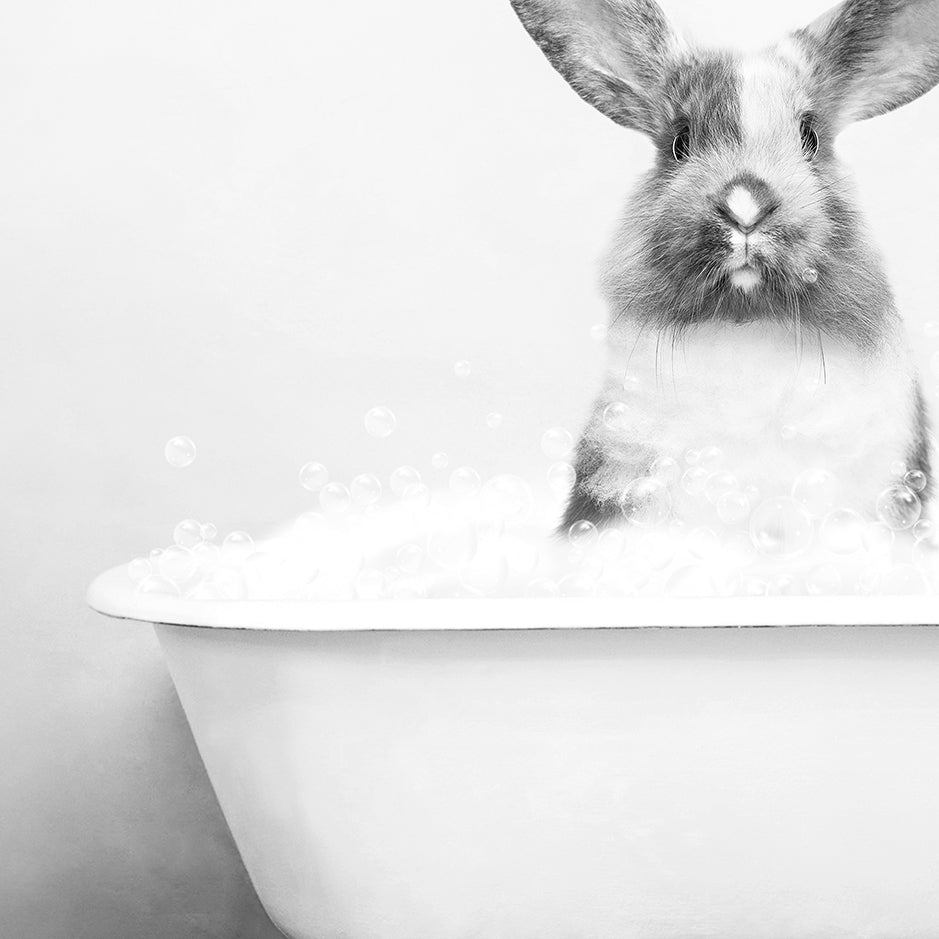 a rabbit is sitting in a bathtub full of bubbles