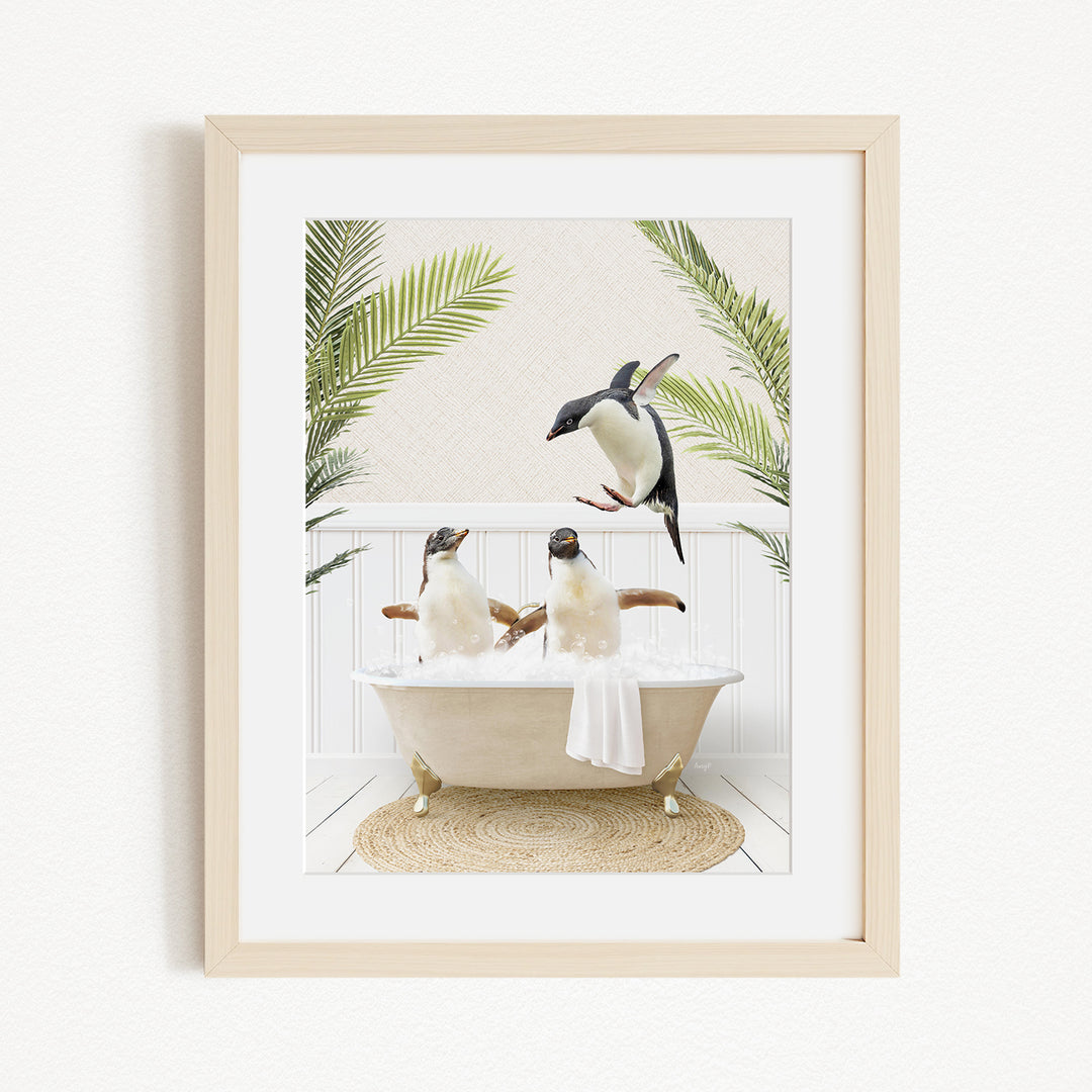 A framed image depicting three penguins sitting in a bathtub, surrounded by palm leaves.