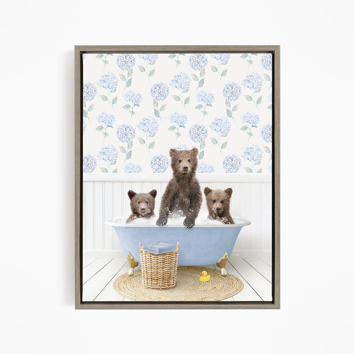 A framed image depicting three bears sitting in a bathtub filled with water, surrounded by a floral patterned wallpaper.