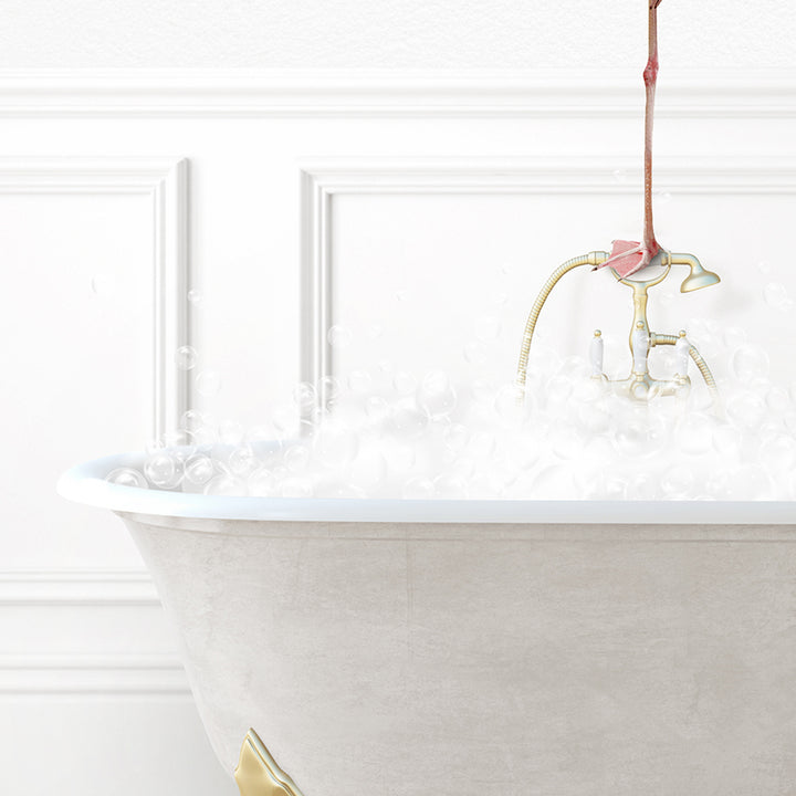 a bathtub filled with white foam and a gold faucet