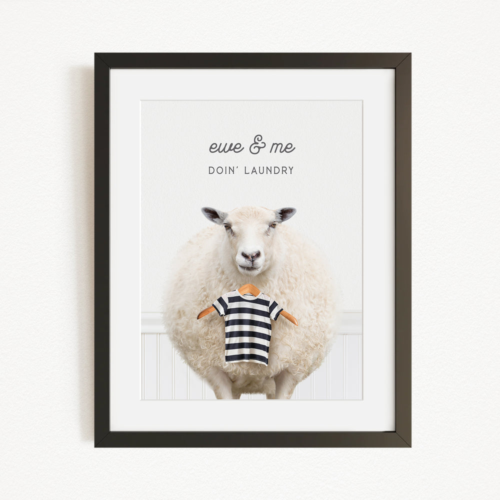 A framed image of a sheep wearing a striped shirt, with the text "eue & me DO'N Laundry" written above it.
