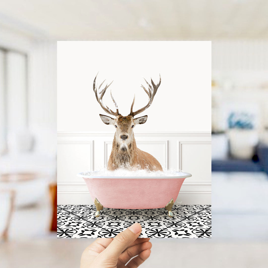 A deer with antlers is sitting in a pink bathtub filled with bubbles, creating a whimsical and unexpected scene.
