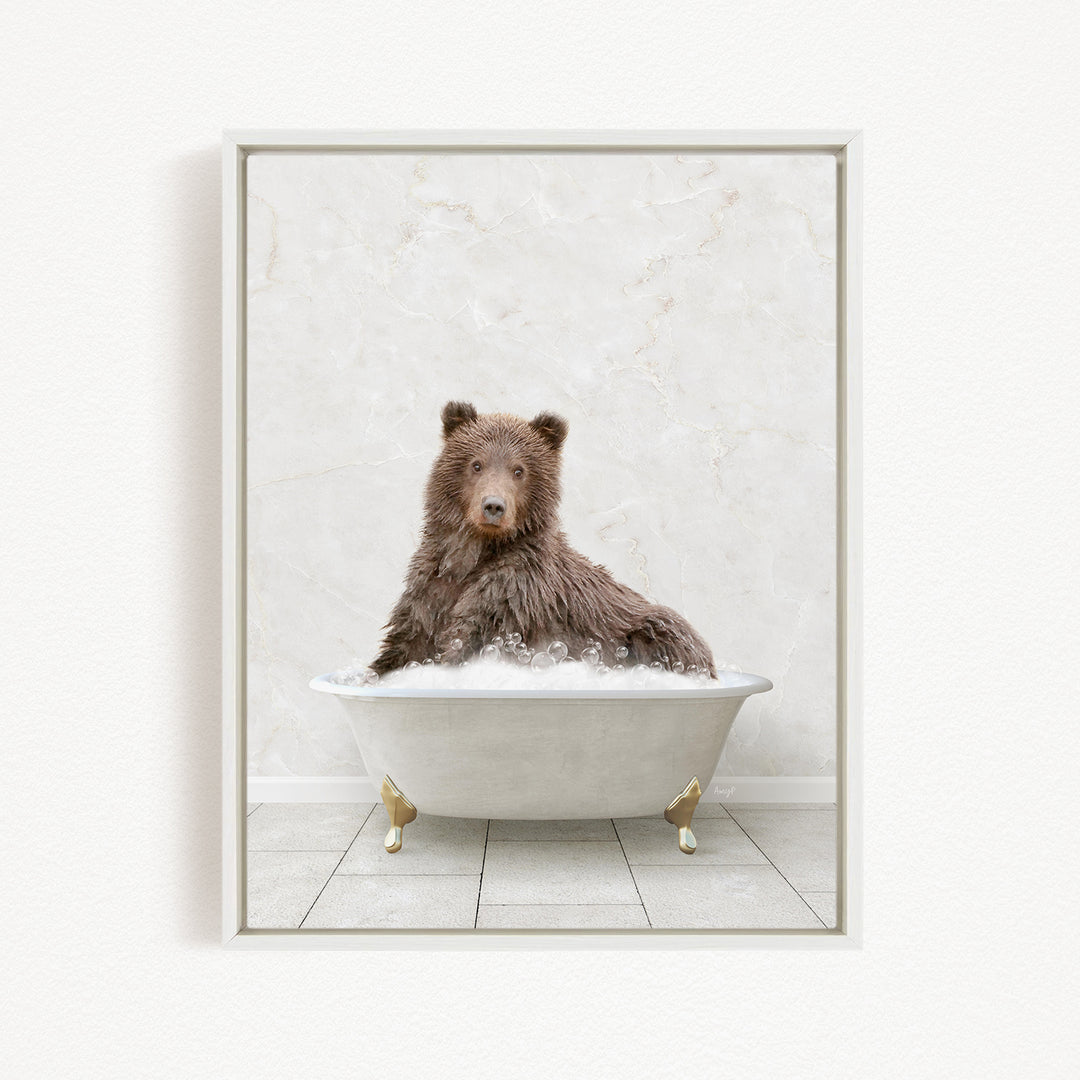 A brown bear sitting in a white bathtub filled with water, looking directly at the camera.