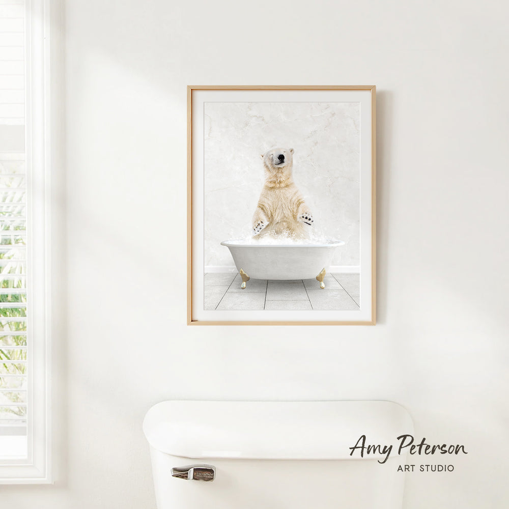 A framed image of a polar bear sitting in a bathtub, with the polar bear's paws raised in the air.