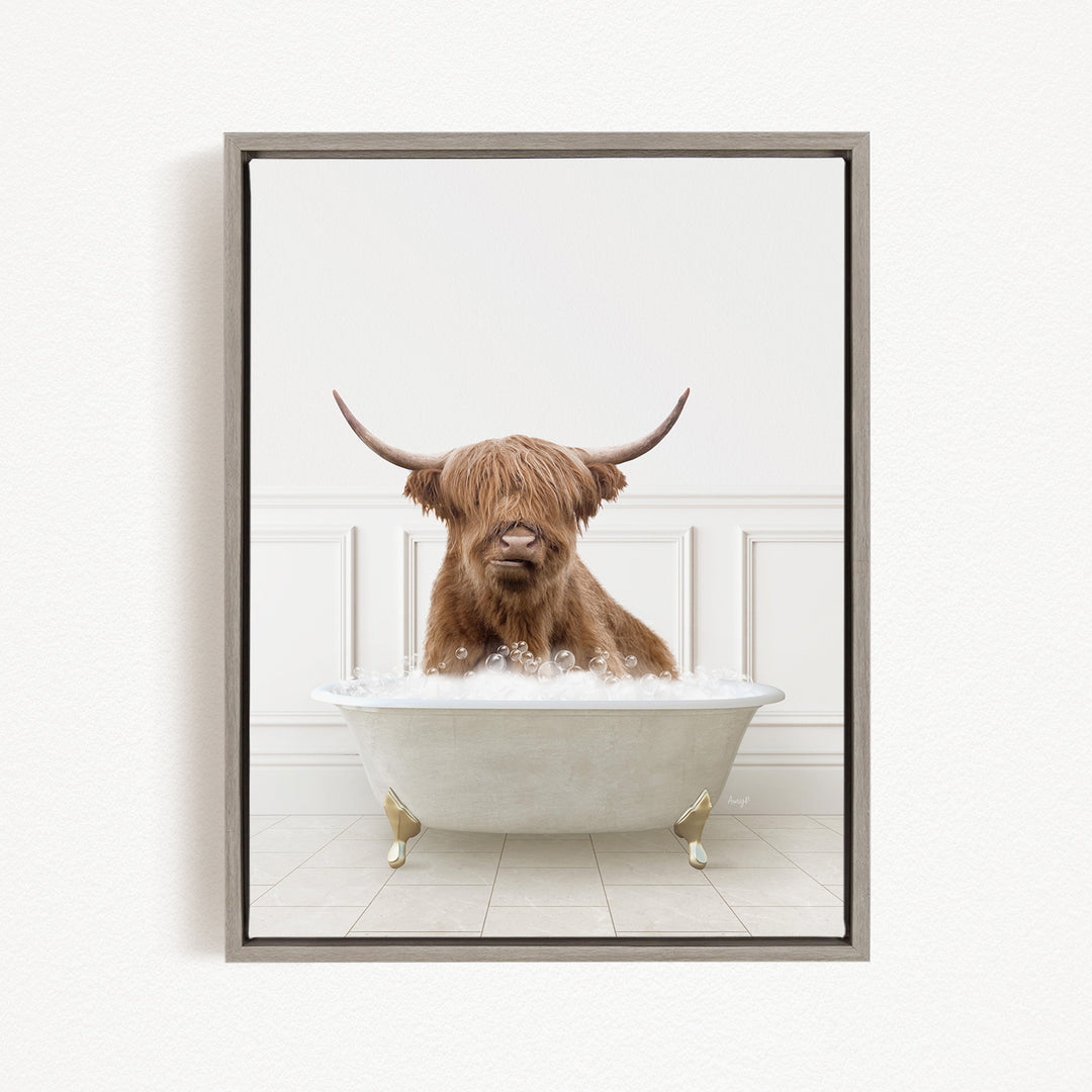 A Highland cow with long horns is sitting in a white bathtub filled with bubbles, appearing to enjoy the bath.