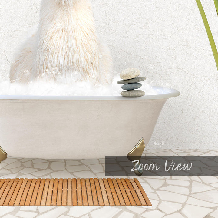 A fluffy white cat is sitting in a bathtub filled with bubbles, with a stack of rocks on the edge of the tub.