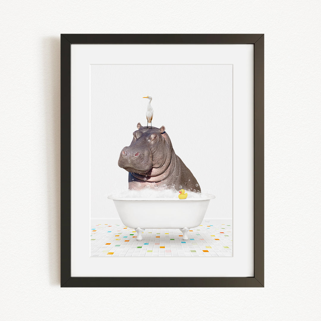 A framed image depicting a hippopotamus sitting in a bathtub, with a bird perched on its head.