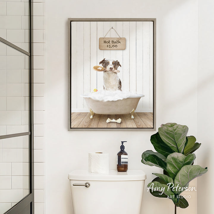 A framed image of a dog sitting in a bathtub, holding a toy, with a sign above it that says "Hot Bath is Fun".