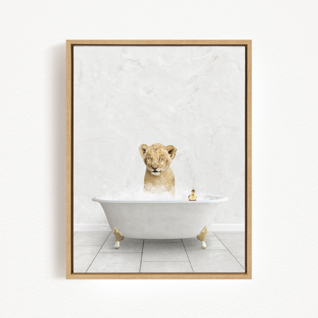 A young lion cub sitting in a white bathtub filled with bubbles, looking up at the camera.