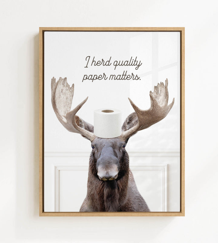 A moose wearing a roll of toilet paper on its head, with the text "I herd quality paper matters" above it.