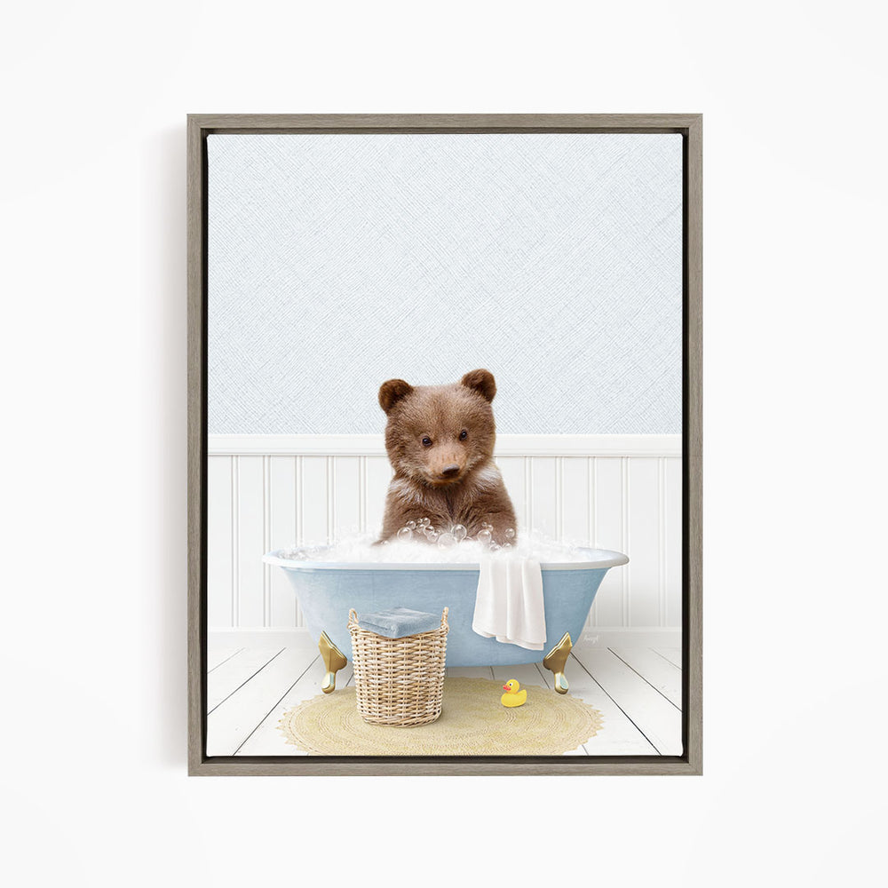A brown bear sitting in a blue bathtub filled with water, surrounded by a yellow rubber duck and a basket.