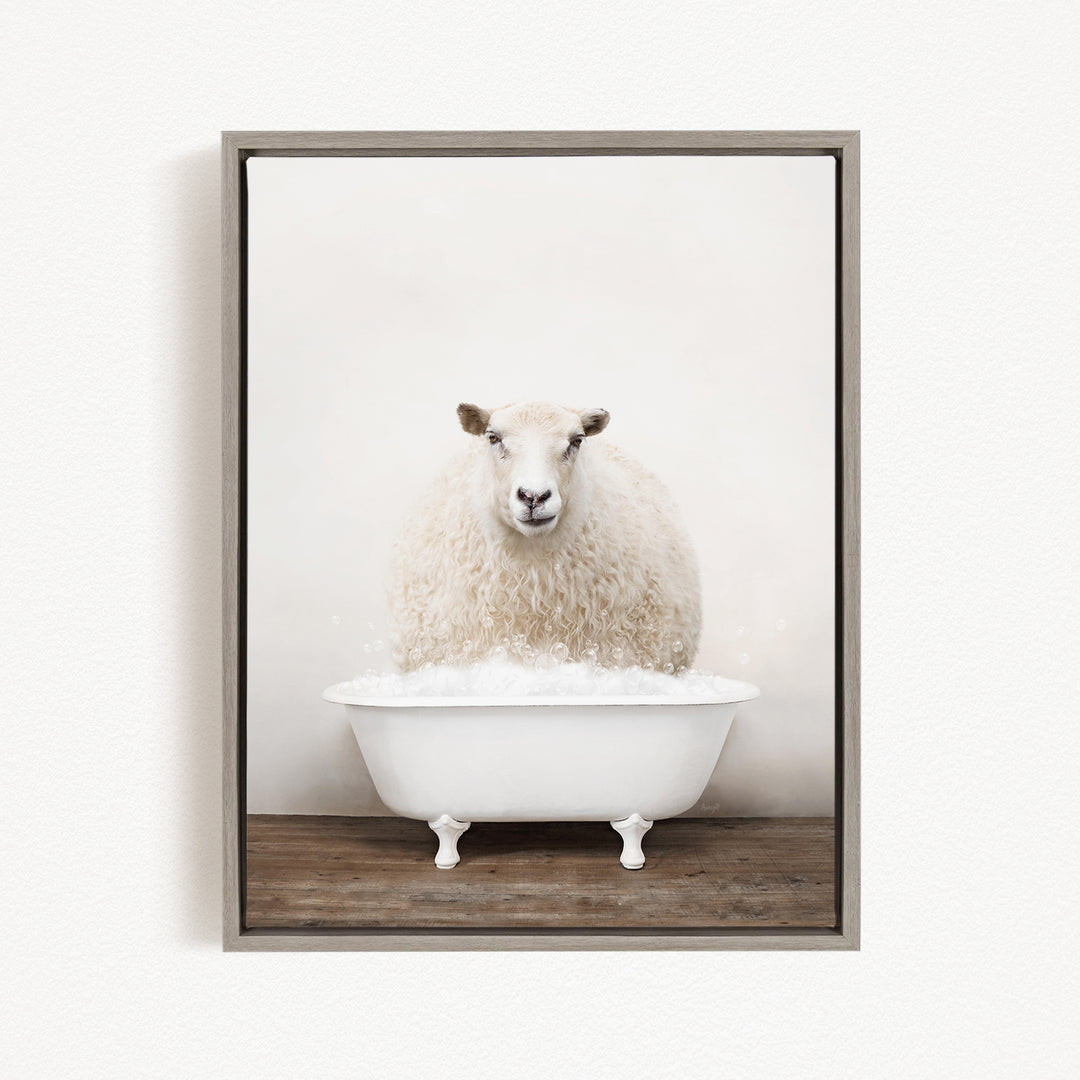 A fluffy white sheep sits in a white bathtub filled with bubbles, looking directly at the camera.