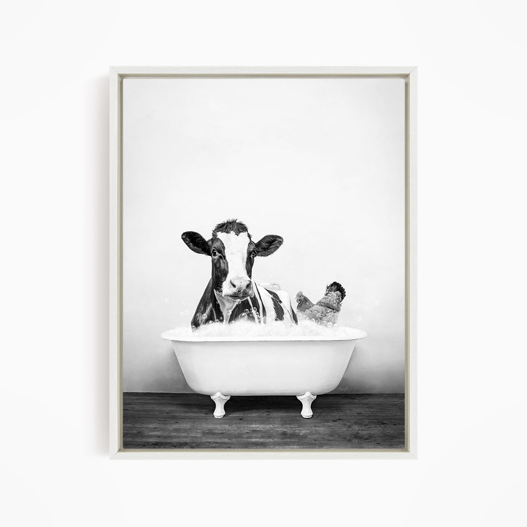 A black and white image of a cow sitting in a bathtub, with a chicken standing nearby.