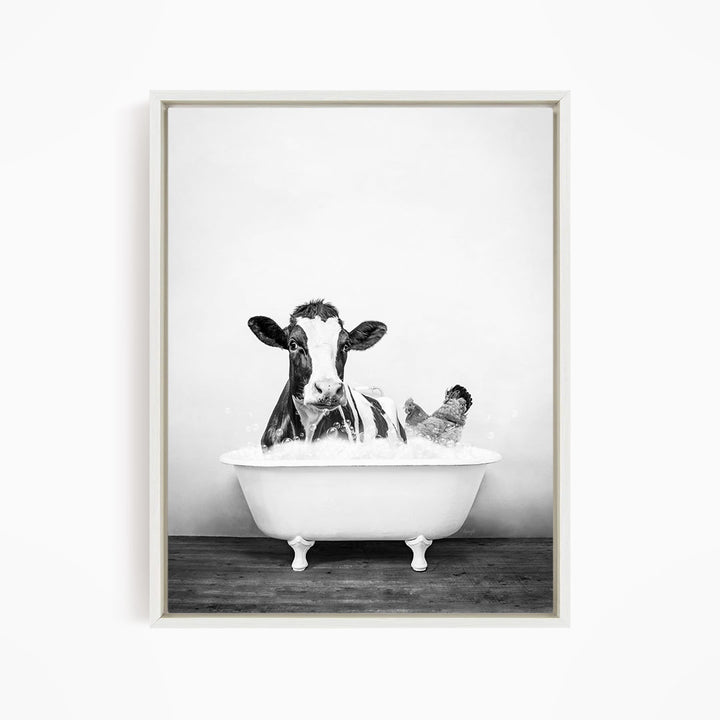A black and white image of a cow sitting in a bathtub, with a chicken standing nearby.