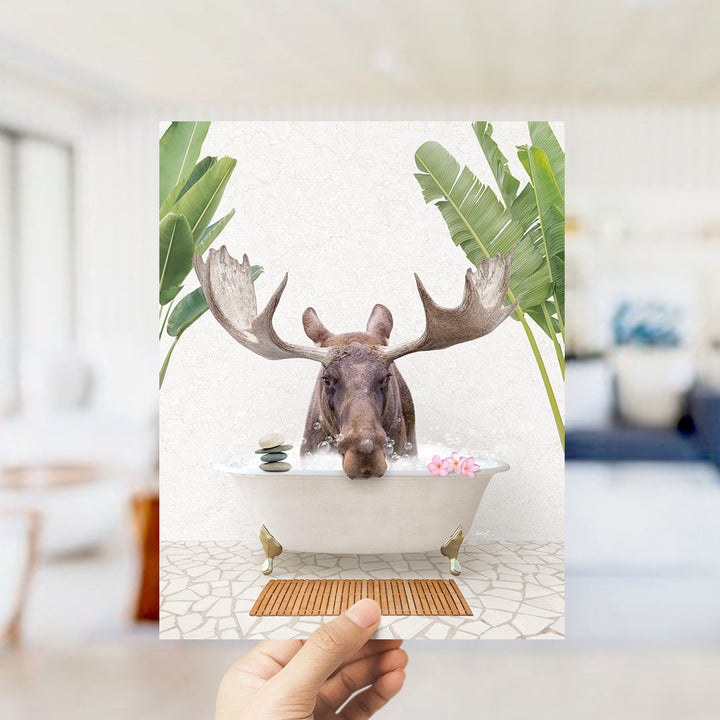 A moose with large antlers is sitting in a bathtub filled with water, surrounded by tropical plants.