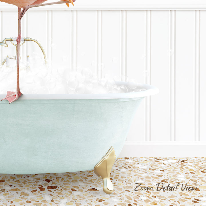 A light blue claw-foot bathtub filled with water and bubbles, with a gold-colored claw on the side, set against a white wall with a tiled floor.