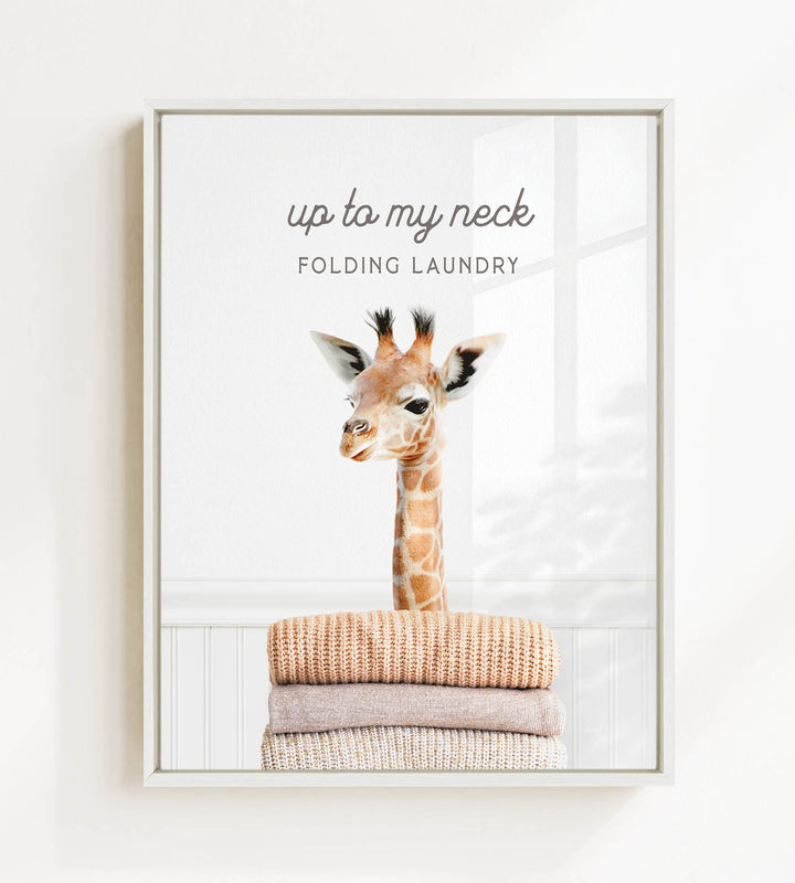 A giraffe peeking over a stack of folded clothes, with the text "up to my neck" and "FOLDING LAUNDRY" displayed above the image.
