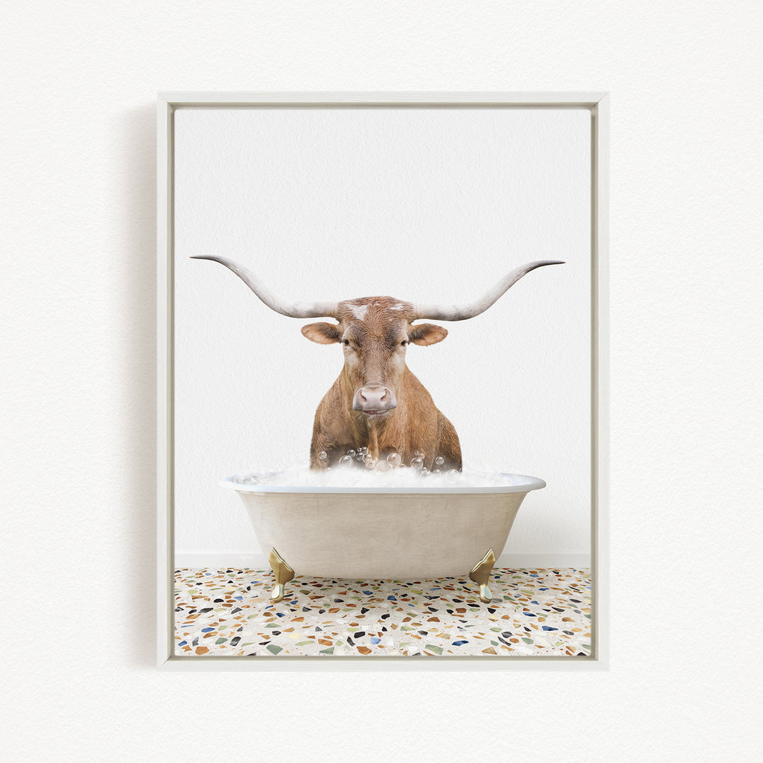 A brown bull with long horns is sitting in a white bathtub filled with water, creating a whimsical and playful scene.