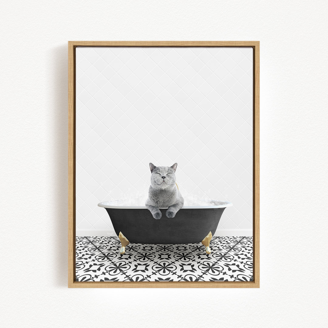 A gray cat sitting in a black bathtub filled with bubbles, surrounded by a black and white patterned floor.