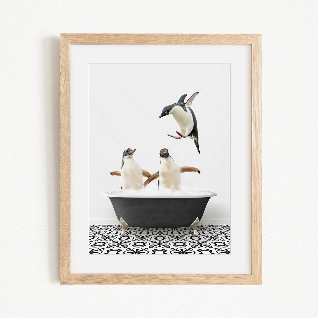 A framed image depicting two penguins sitting in a bathtub, with one penguin flying towards the other.