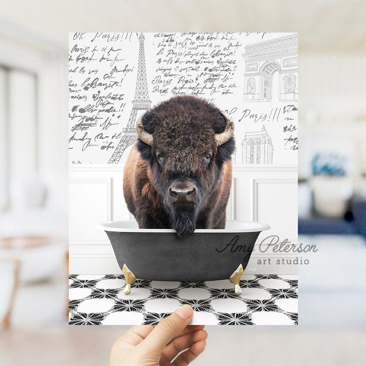 a person holding up a card with a picture of a bison in a bathtub