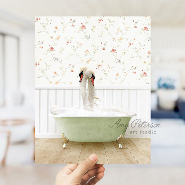 a person holding up a picture of two swans in a bathtub