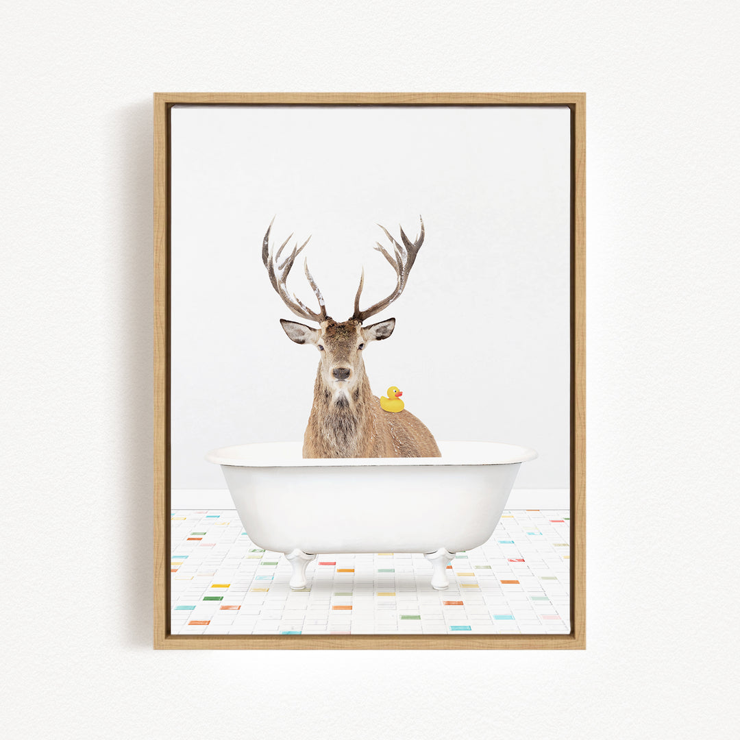A deer with antlers is sitting in a white bathtub, with a rubber duck perched on its back.