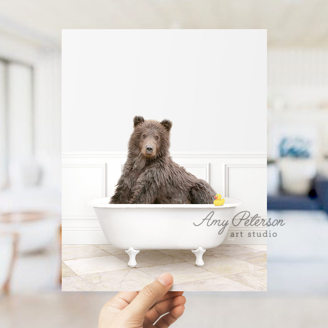 a person holding up a polaroid picture of a bear in a bathtub