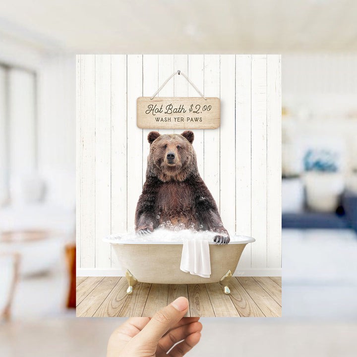A brown bear sitting in a bathtub, with a sign above it that says "Hot Bath $2.00 WASH YER Paws".