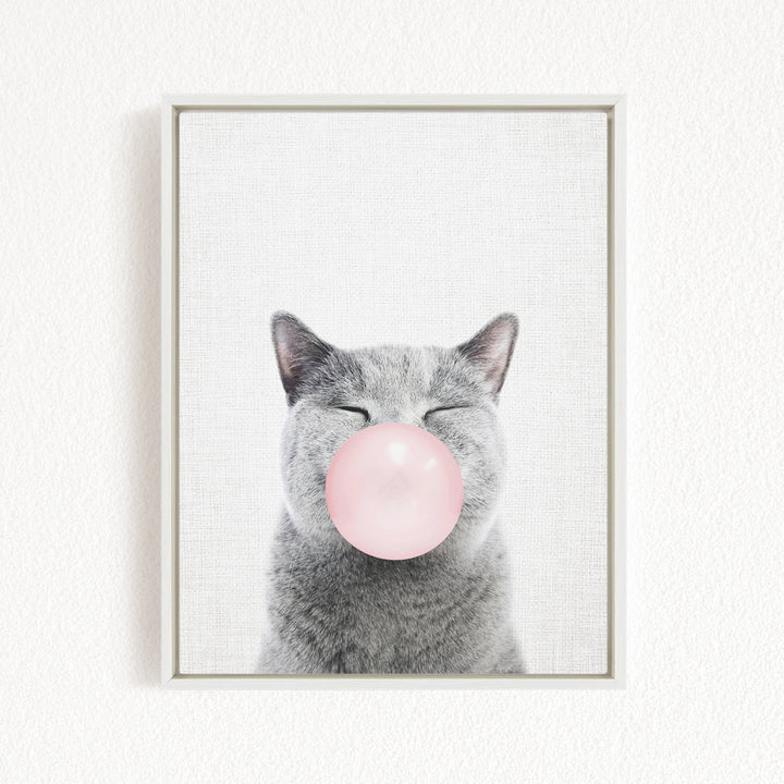 A gray cat with its eyes closed and a pink bubble blowing in its mouth.