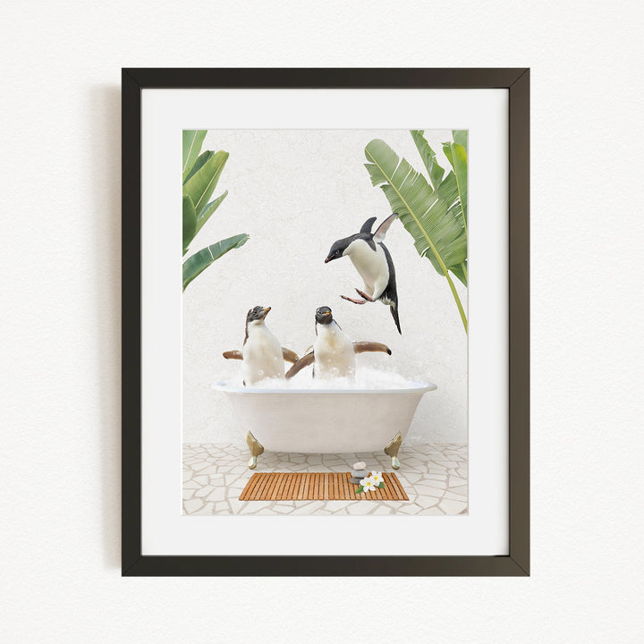 A framed image depicting three penguins sitting in a bathtub, surrounded by tropical plants and flowers.