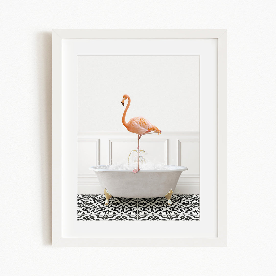 A framed image of a flamingo standing in a white bathtub filled with water, set against a white wall and black and white patterned floor.