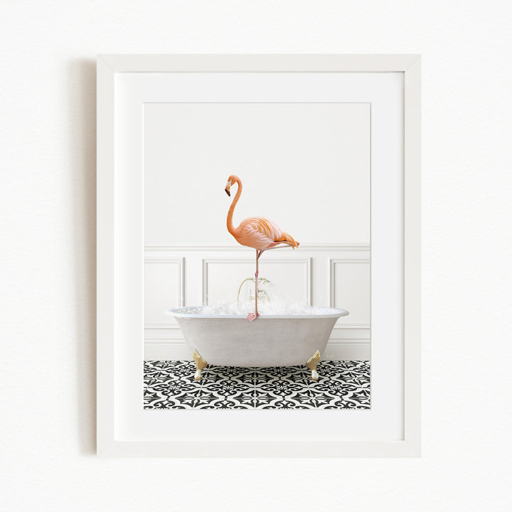A framed image of a flamingo standing in a white bathtub filled with water, set against a white wall and black and white patterned floor.