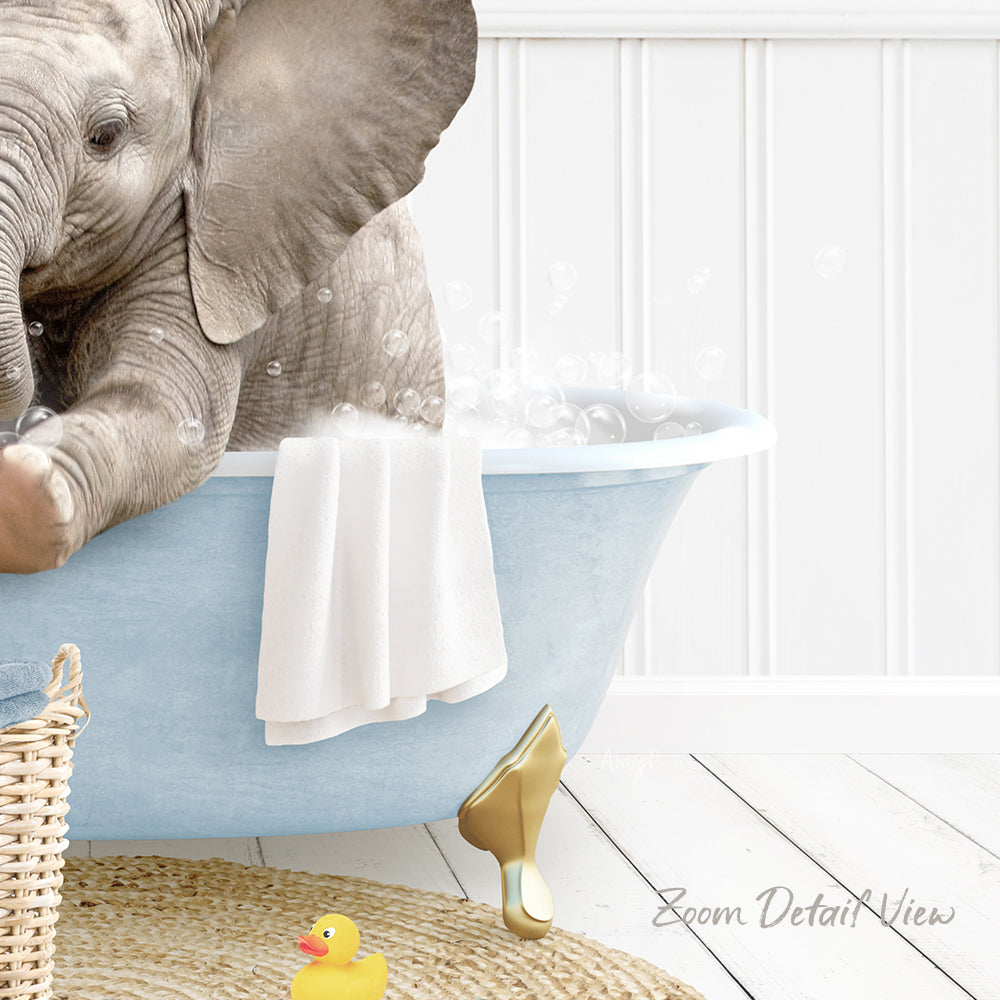 A baby elephant sitting in a blue bathtub, surrounded by bubbles and a towel, with a yellow rubber duck nearby.
