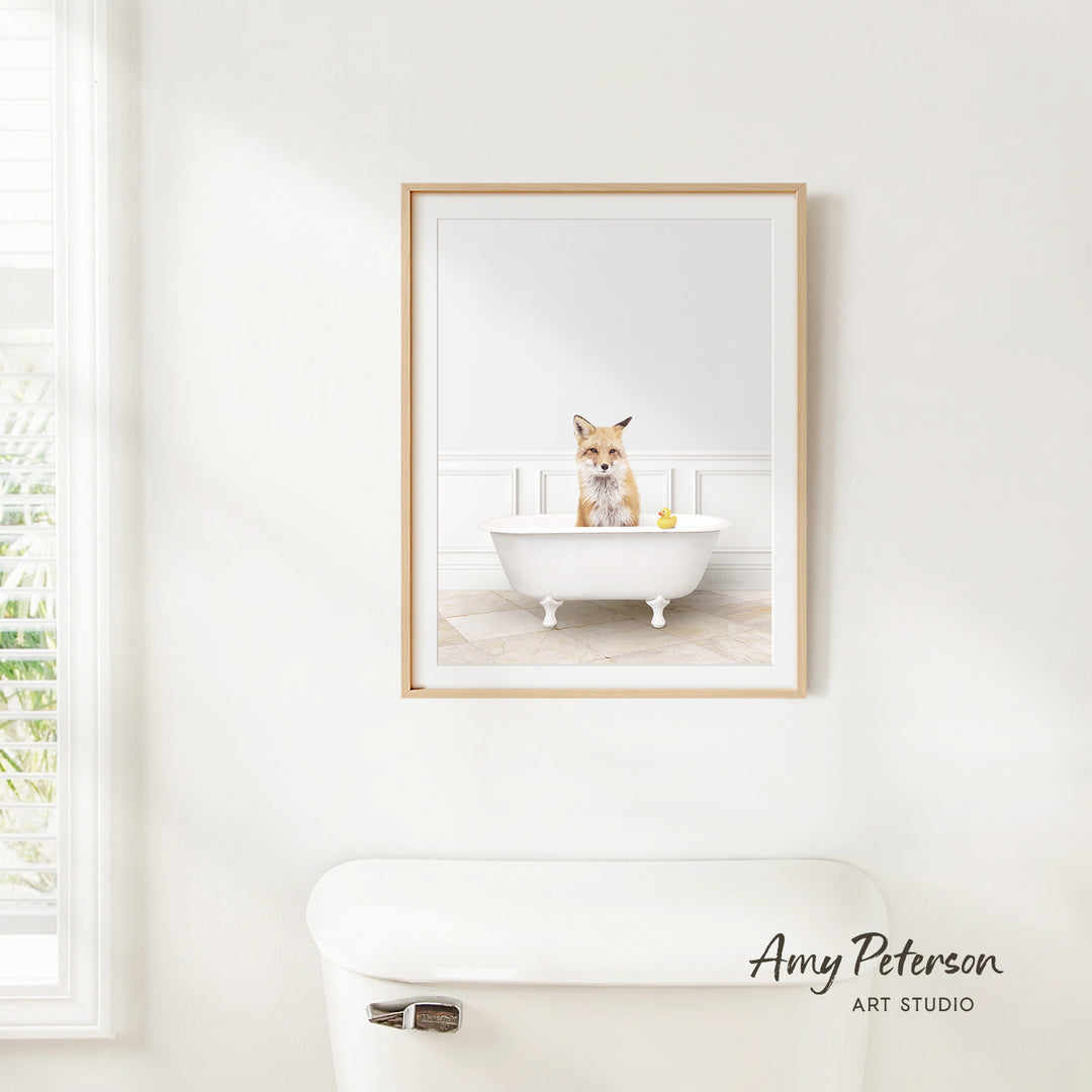 A framed image of a cat sitting in a bathtub, with a yellow rubber duck floating in the water.