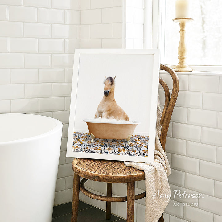 A framed image of a horse sitting in a bathtub, surrounded by a patterned tile design.