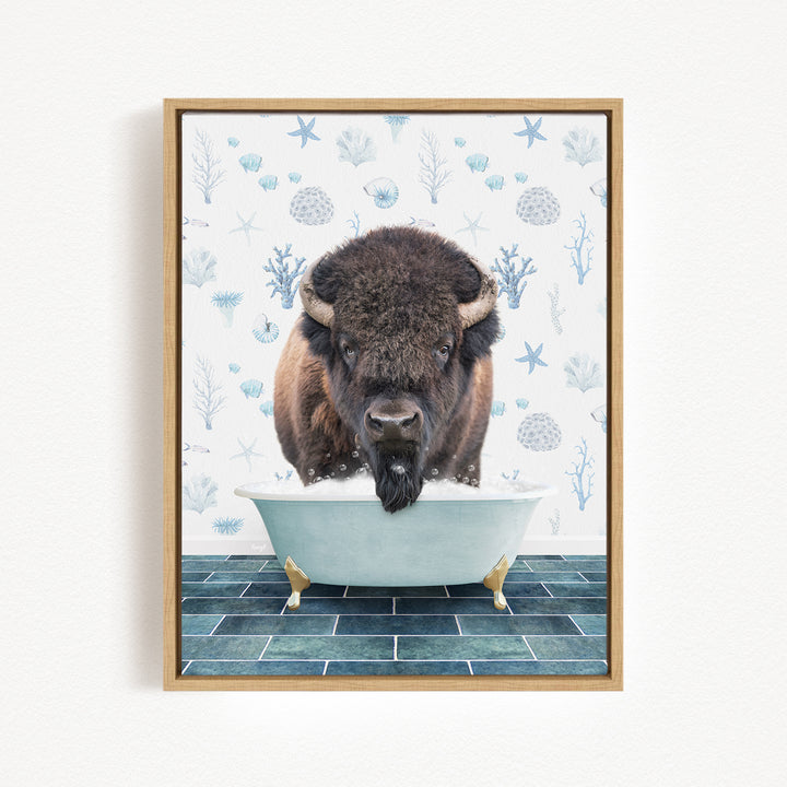A buffalo is sitting in a bathtub filled with water, surrounded by blue and white floral patterns on the wall behind it.