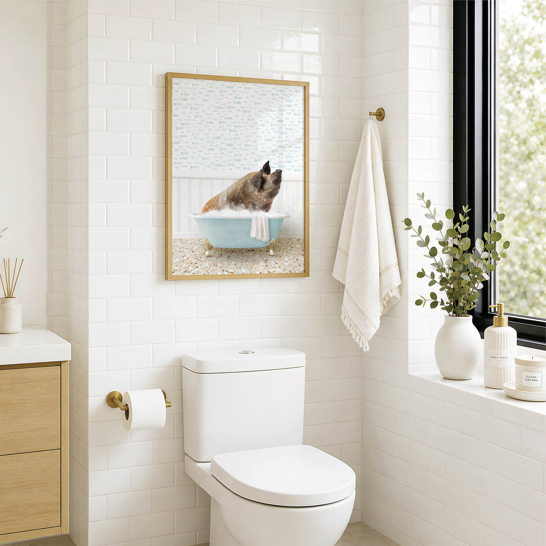 A bathroom with a white toilet, a framed picture of a pig in a bathtub, and a window with greenery on the sill.