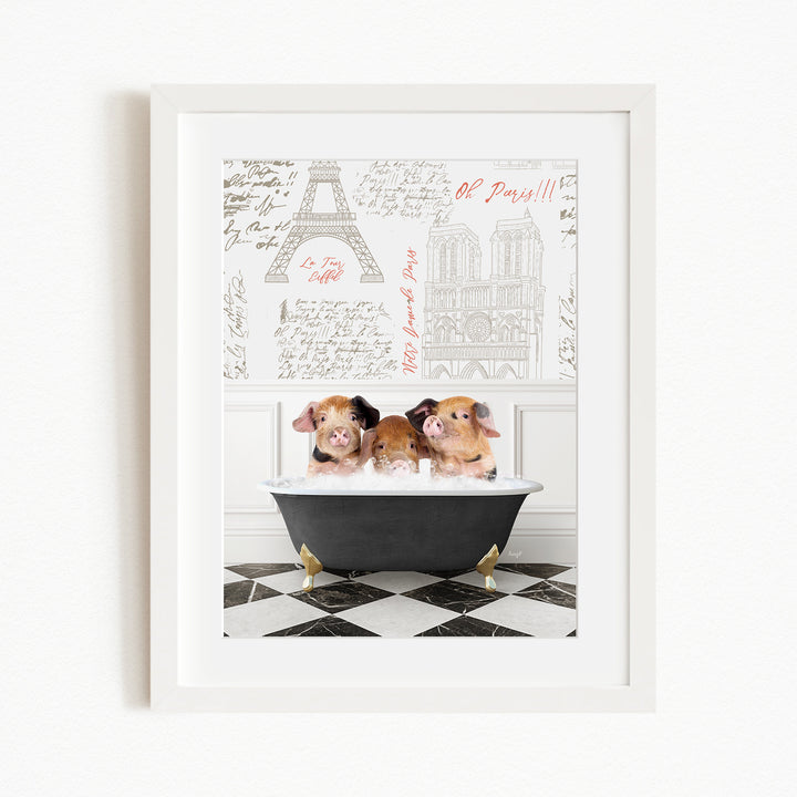 Three adorable pigs sitting in a bathtub, with a framed print of the Eiffel Tower and other Parisian landmarks in the background.