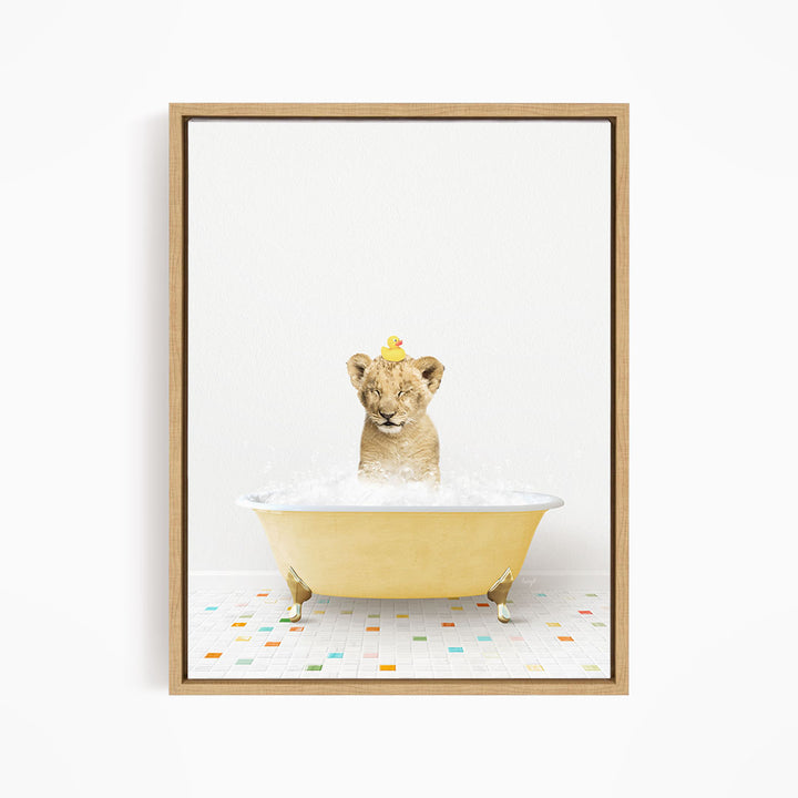 A young lion cub sitting in a yellow bathtub filled with bubbles, with a rubber duck perched on its head.