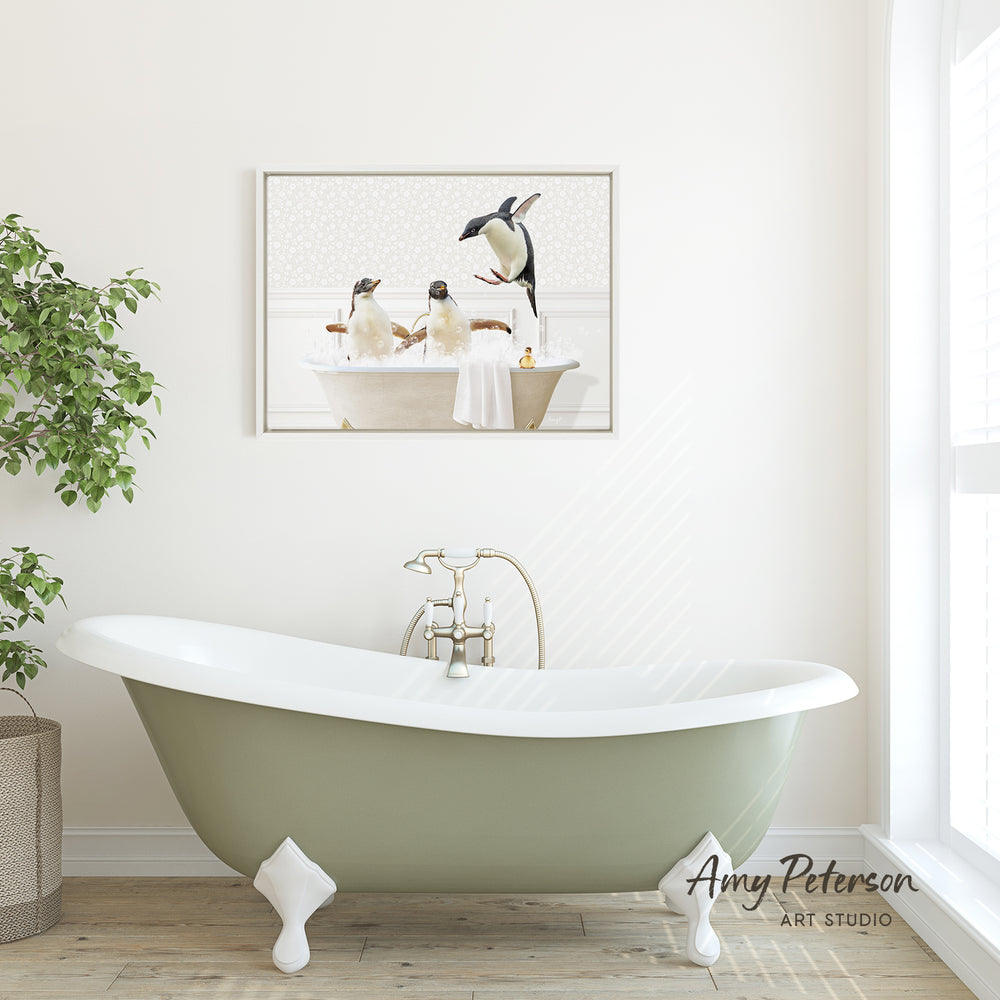 A framed image of two penguins sitting in a bathtub is displayed on the wall above a green clawfoot bathtub in a bathroom.