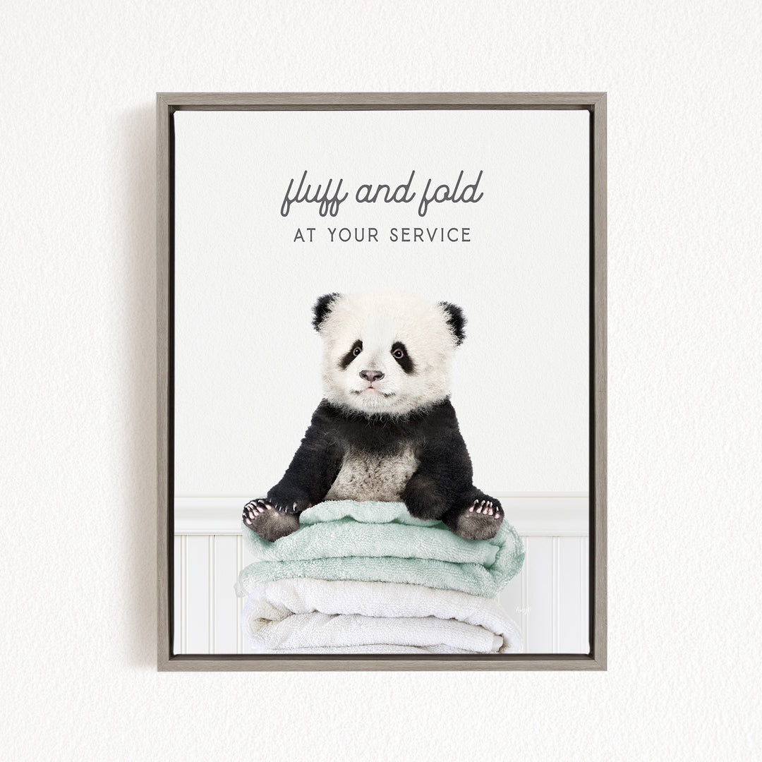 A panda bear sitting on a stack of towels, with the text "fluff and fold at your service" written above the image.