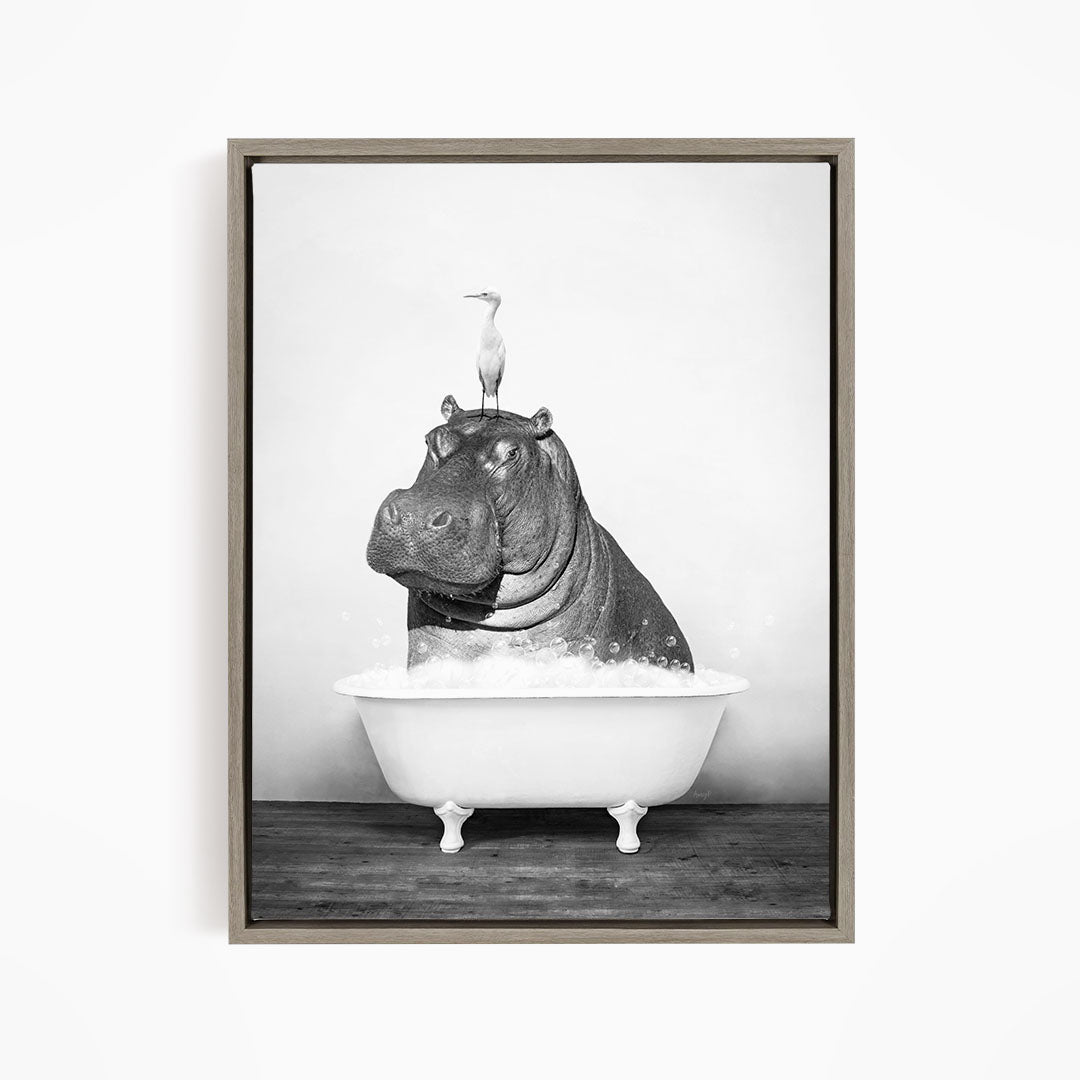 A black and white image of a hippopotamus sitting in a bathtub, with a bird perched on its head.