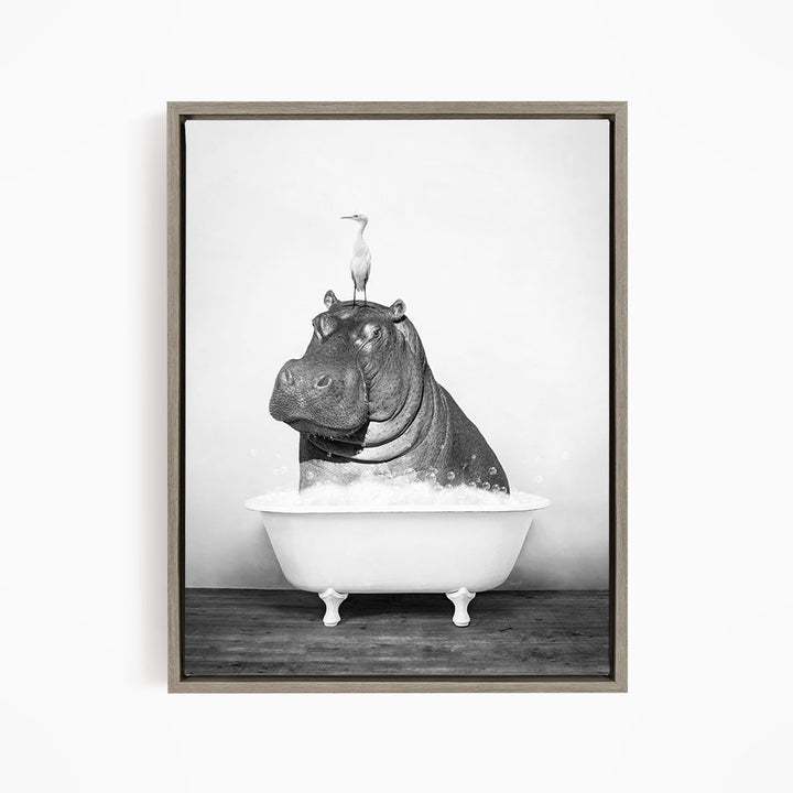 A black and white image of a hippopotamus sitting in a bathtub, with a bird perched on its head.