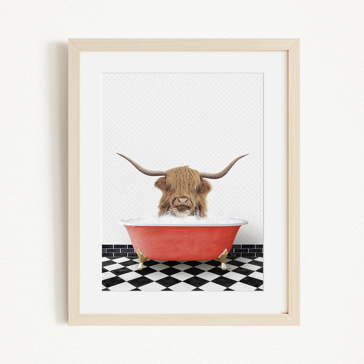 A framed image depicting a Highland cow with long horns sitting in a red bathtub on a black and white checkered floor.