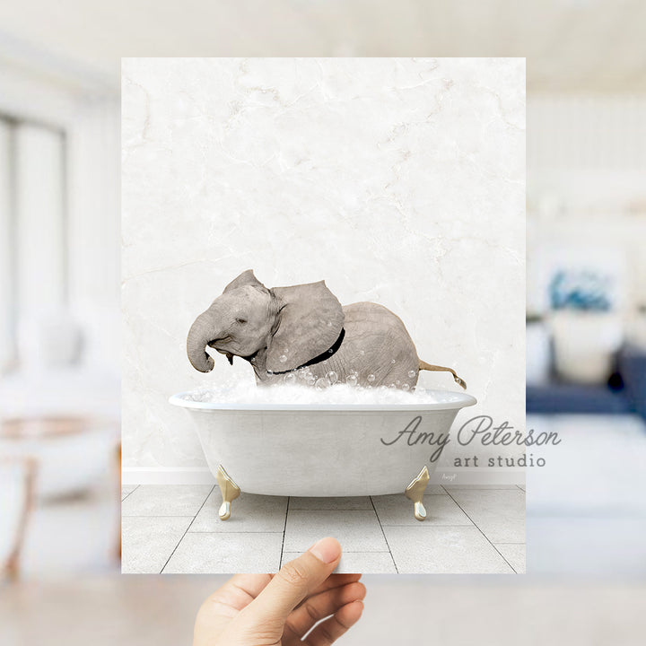 a hand holding up a picture of an elephant in a bathtub