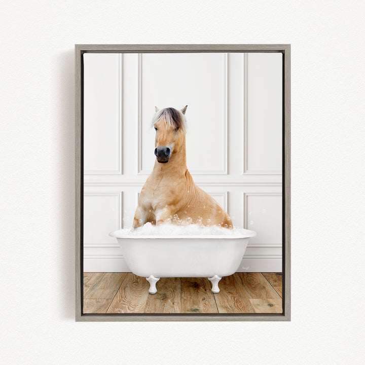 A brown horse sitting in a white bathtub filled with water, with a wooden floor visible beneath the tub.