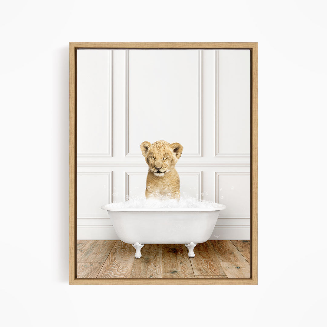 A young lion cub sitting in a white bathtub filled with water, looking up at the camera.