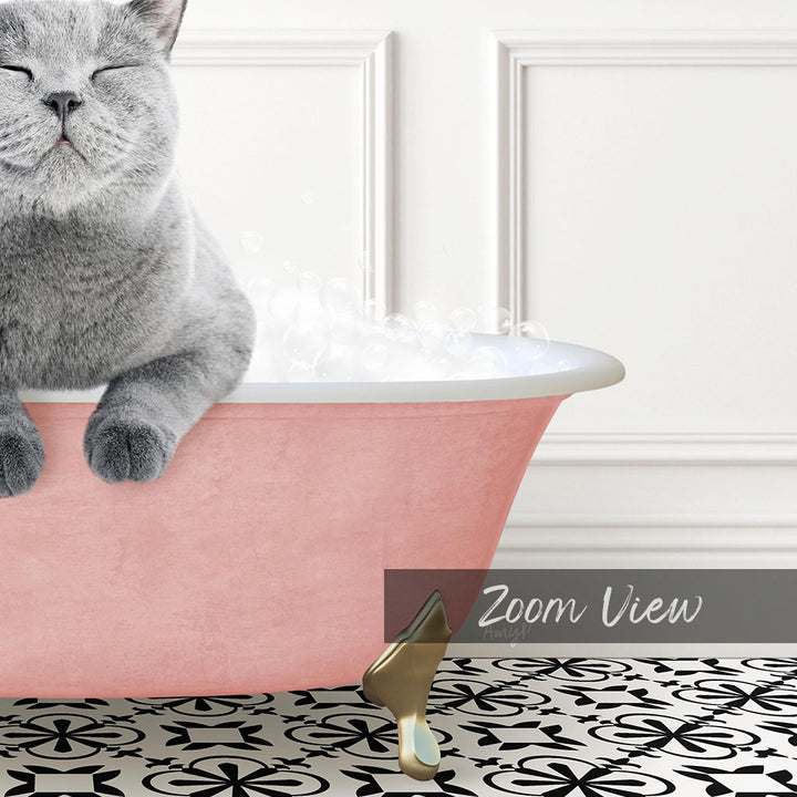 A gray cat sitting in a pink bathtub filled with bubbles, with a gold faucet and a black and white patterned floor in the background.