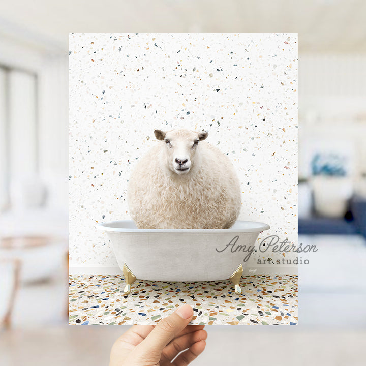 a hand holding a card with a sheep in a bathtub